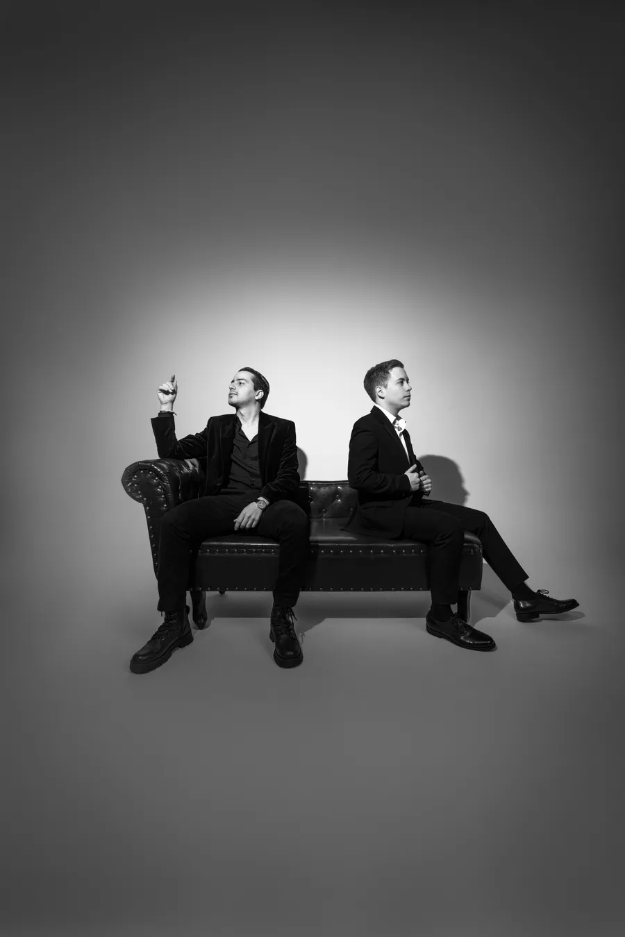 Dos DJs del roster sentados espalda con espalda