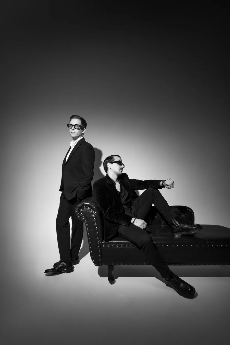 Dos DJs del roster, uno de pie y otro sentado
